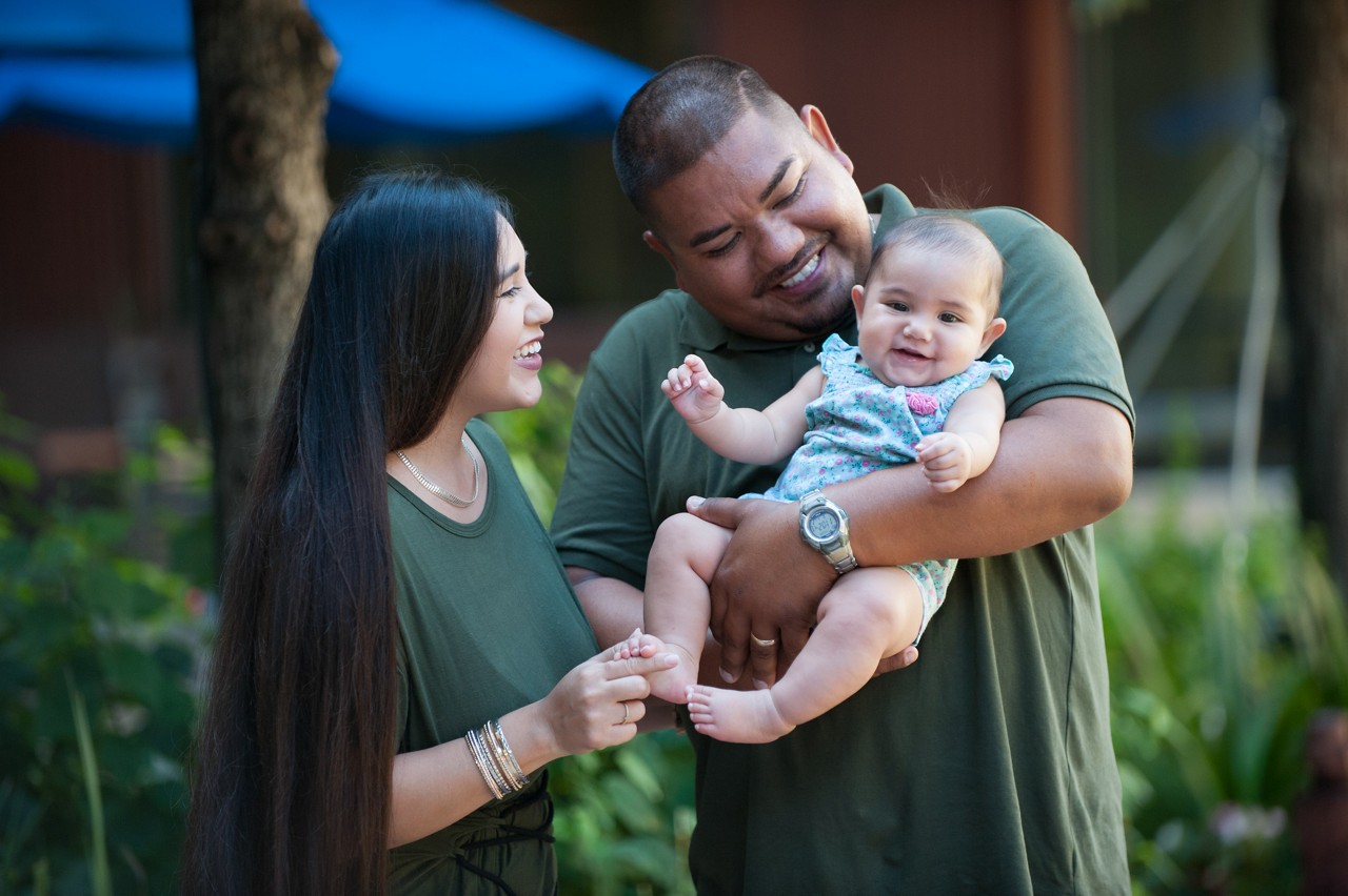 Parents holding their infant child.