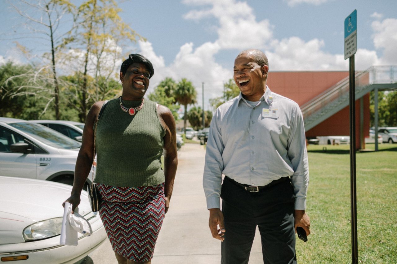 Two residents of Broward County talking and smiling while walking.