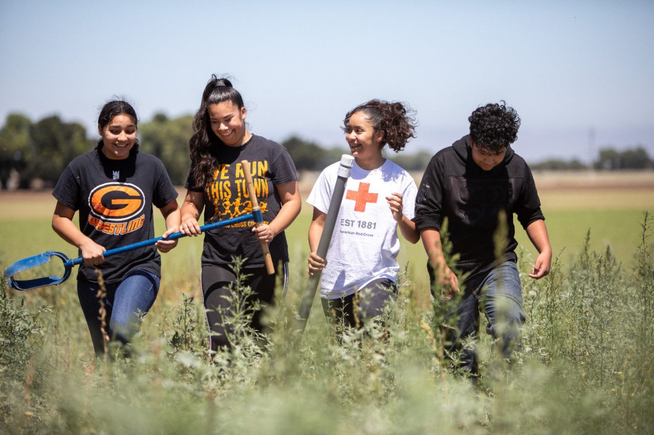 RWJF Culture of Health Prize 2019 - Gonzales, CA. Veronica Rodriguez (left), Maria Lopez (white shirt), Leslie Hernandez (2nd to left in "we run this town " shirt) and Andres Hernandez (the only male here). Wings of Knowledge program, which started in 2015. The program has equipped Gonzales High and Middle school students with a focus on the curriculum application of STEAM: Science, Technology, Engineering, Arts and Mathematics. Wings of Knowledge (WOK) is participatory action-research initiative guided by the non-profit Olinga Learning.  Olinga Learning is dedicated to empowering youth to improve their rural communities.