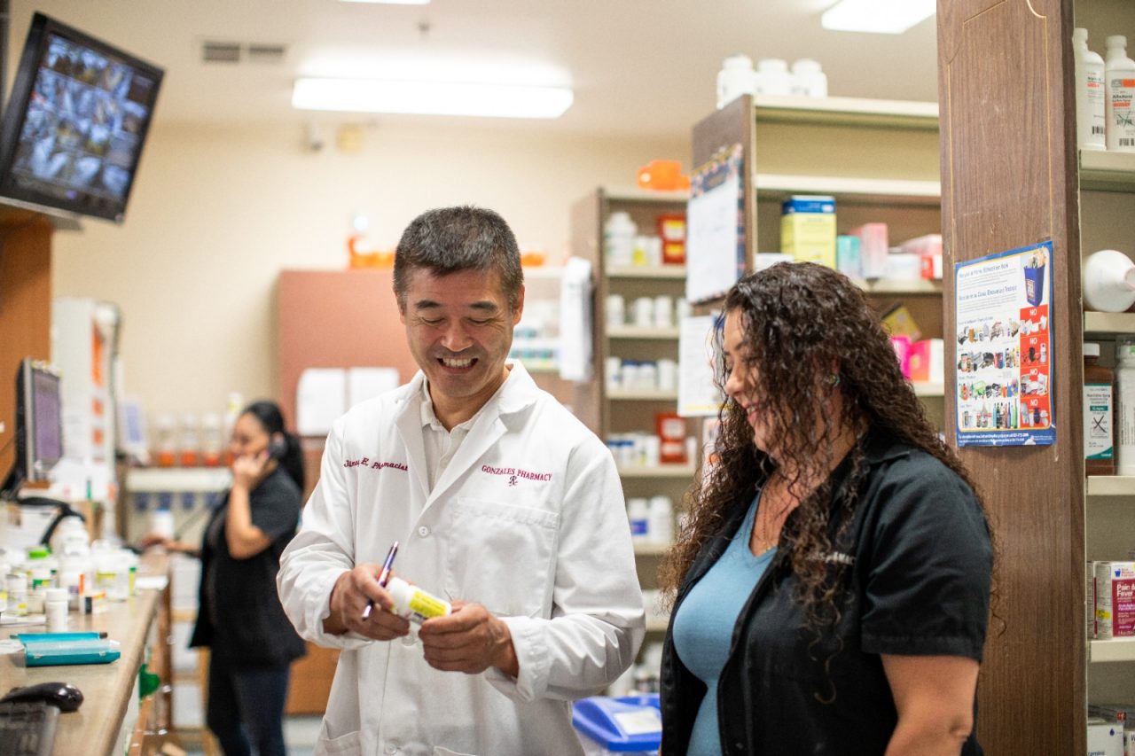 RWJF Culture of Health Prize 2019 - Gonzales, CA.  Jimmy Eitoku (man in white lab coat) has owned Gonzales Pharmacy for 26 years. He lives and grew up in nearby Salinas, CA. Jimmy received a  city-backed low interest business loan to start walk-in sonogram clinic, which is located in Gonzales pharmacy. Rosa Leon (right) and Imelda Lopez (left) are both Pharmacy Technicians.