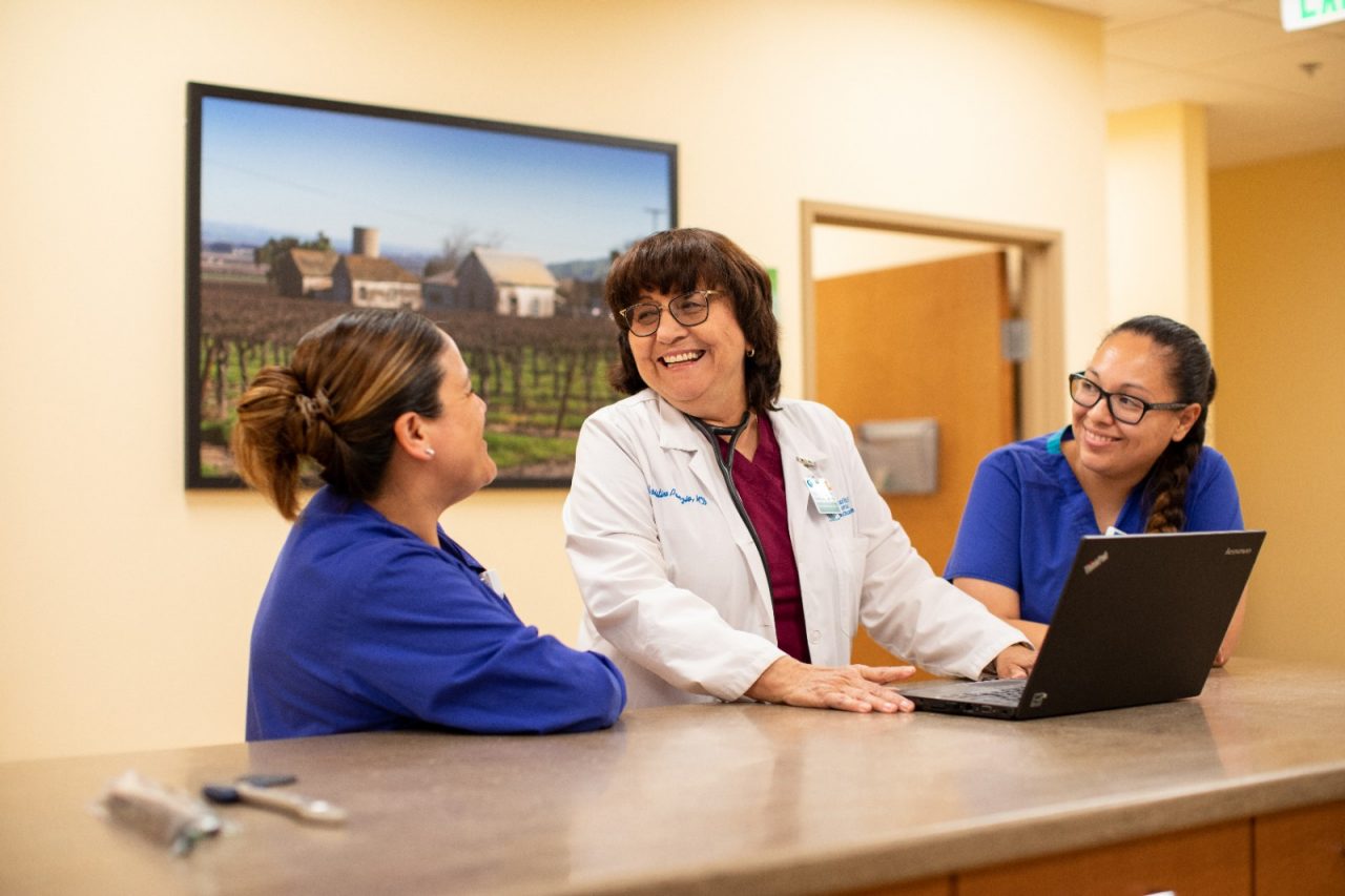 RWJF Culture of Health Prize 2019 - Gonzales, CA. Dr. Christine Ponzio (white lab coat) with nurses Patricia Perez (right) and Lorena Ortic (left) at the Taylor Farms Family Health and Wellness Center. Opened in November 2015, the Taylor Farms Family Health and Wellness Center is designed to provide state-of-the-art care. The 6,400 square foot facility employs four bilingual medical providers and is supported by a bilingual staff in order to better accommodate  communication needs. In partnership with Dr. Christine Ponzio. The center focuses on prevention, wellness and disease management. the center has over 25,000 visits a year.