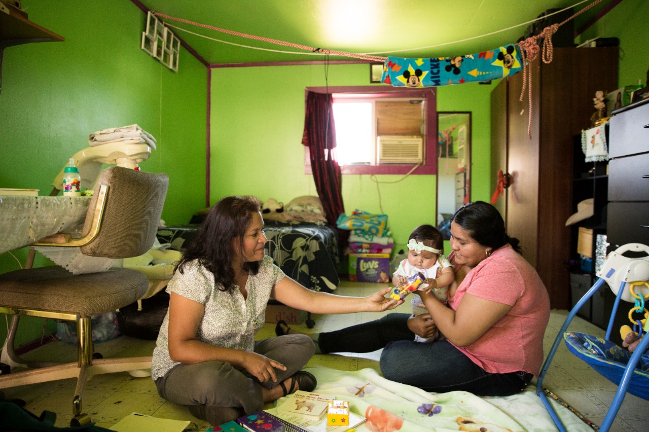 Two women caring for a infant at home.