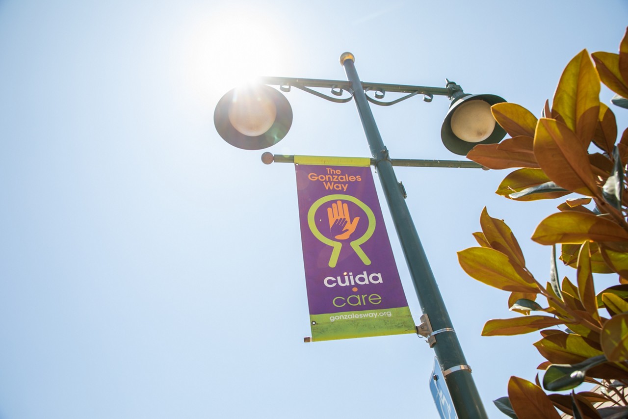 A town sign hanging from a street lamppost.