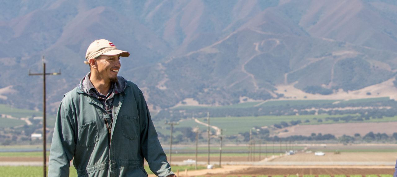 RWJF Culture of Health Prize 2019 - Gonzales, CA. Januario Lopez Martinez (blue sweatshirt) and Trinidad Zavala  (green overalls). They are inspecting drip irrigation lines. This irrigation system saves water and provides uniform plant growth. These men are farmers who work land owned by the Franscioni family. This land was origianlly purchased by Michael Franscioni's grandfather in 1903. The land now belongs to Michael's brother Ray. The land will stay in the family for another generation when Ray's kids are ready to run it.