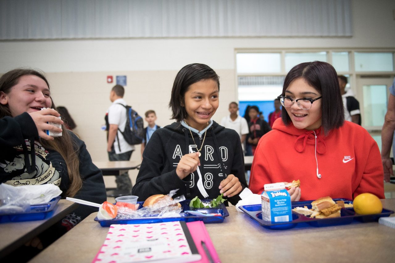 Students eat lunch in the cafeteria at Tanglewood Middle School, which participates in a healthy school lunch program. The Food and Nutrition Services department sources from local farms and receives extra training to create healthier meal options for students.