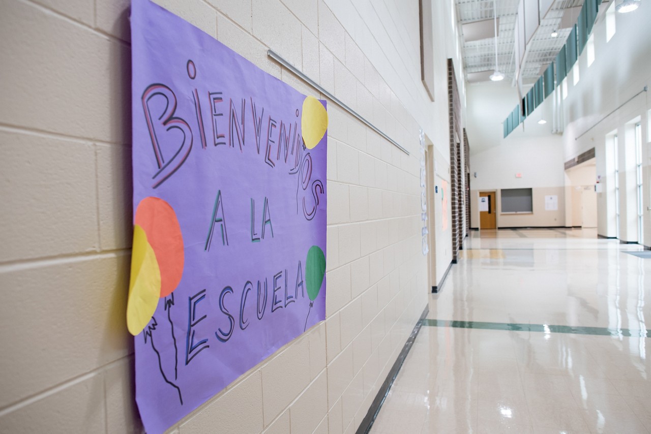 A sign in Spanish welcomes students to school.