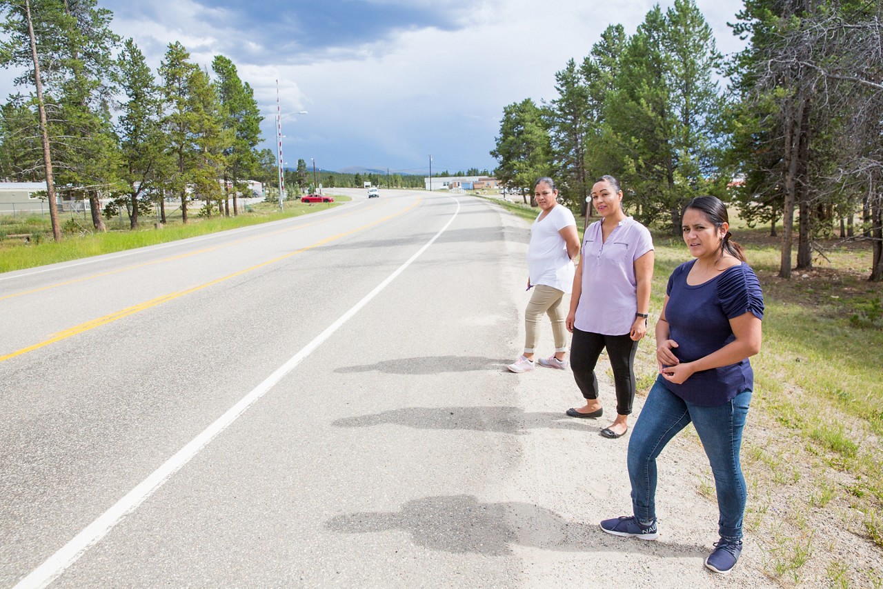 Three women stand on the busy state-owned highway next to the Mountain View manufactured housing community in Lake County, Colo.