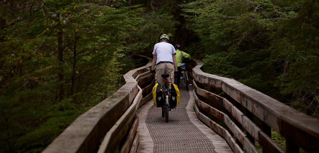 Bicyclists riding on a wooden bike trail.