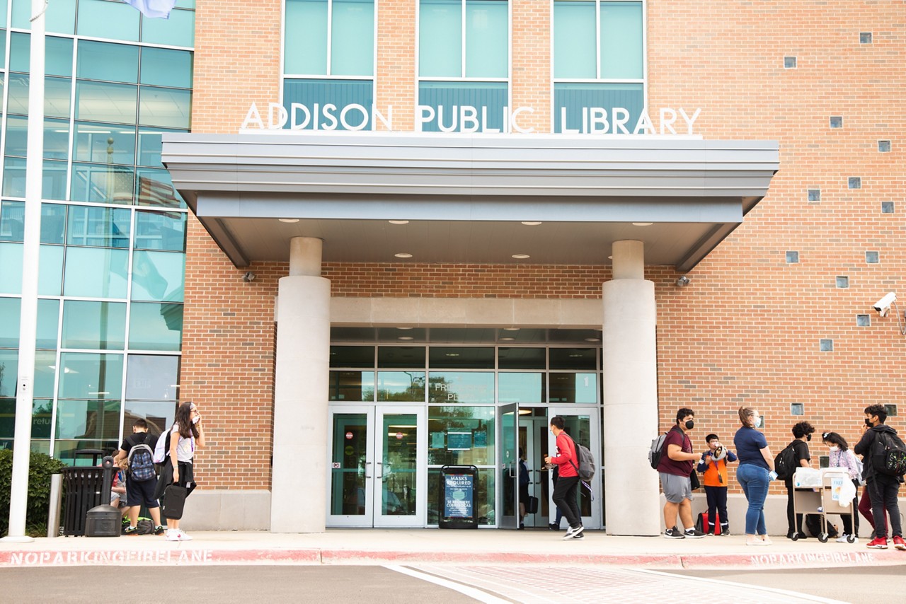 People standing outside the entrance of a public library.