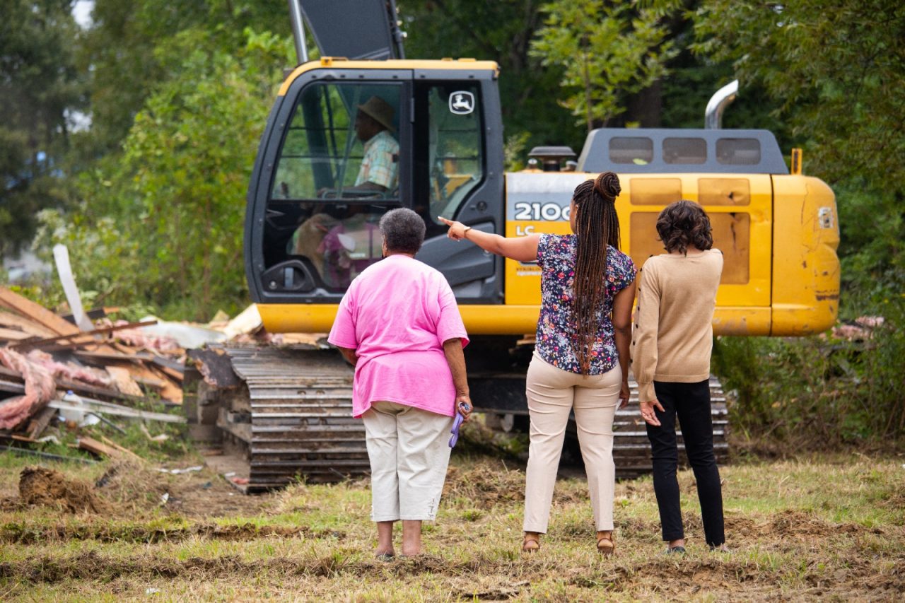 Mary Phillips, Tierra Fountain and Gloria Dickerson watch the demolition of an abandoned home in Drew, Mississippi.  Demolishing abandoned homes is part of a larger effort to build pathways to home ownership with affordable housing and improving the physical environment in Drew.