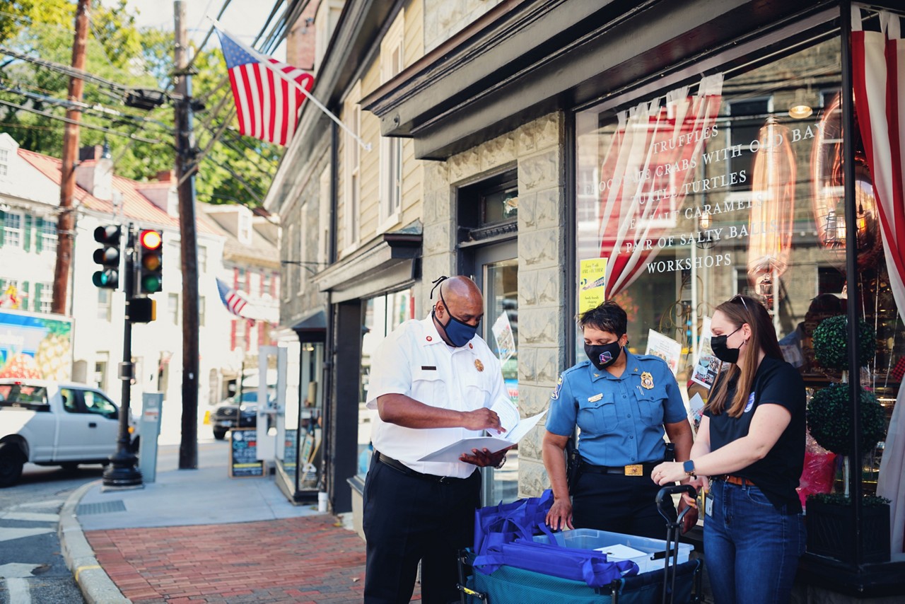 A policeman handing out emergency preparedness kits.