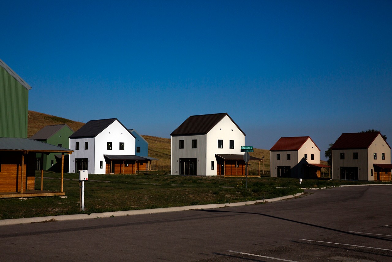 Financial sovereignty, including home ownership and community, is a key pillar of the Thunder Valley Community Development Corporation (TVCDC). The TVCDC’s long-term plan includes dozens of homes including these three-bedroom homes in various state of construction. Multiple are already homes to local families. In a spiritual nod to Lakota culture and history, the homes form a circle and the front door faces East, towards the morning sun.
The people of Thunder Valley are tapping their warrior spirits to reclaim their identities, culture, and language. They are committed to clearing a path forward for generations to come. At the core of the Culture of Health journey is how action is taken by the community—not for the community. The mission includes reclaiming language and culture, healing from trauma, providing homes and creating a safe and regenerative community, and developing work-force skills by looking at the whole person and getting them ready for the workforce physically, mentally, socially, and spiritually. Pine Ridge Reservation, South Dakota. September 15, 2021 (Photo by Samantha Appleton) Financial sovereignty, including home ownership and community, is a key pillar of the Thunder Valley Community Development Corporation (TVCDC). The TVCDC’s long-term plan includes dozens of homes including these three-bedroom homes in various state of construction. Multiple are already homes to local families. In a spiritual nod to Lakota culture and history, the homes form a circle and the front door faces East, towards the morning sun.
The people of Thunder Valley are tapping their warrior spirits to reclaim their identities, culture, and language. They are committed to clearing a path forward for generations to come. At the core of the Culture of Health journey is how action is taken by the community—not for the community. The mission includes reclaiming language and culture, healing from trauma, providing homes and creating a safe and regenerative community, and developing work-force skills by looking at the whole person and getting them ready for the workforce physically, mentally, socially, and spiritually. Pine Ridge Reservation, South Dakota. September 15, 2021 (Photo by Samantha Appleton)