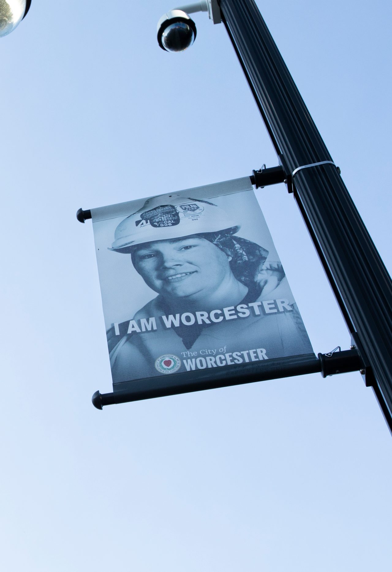 A banner hanging on a solar streetlight.