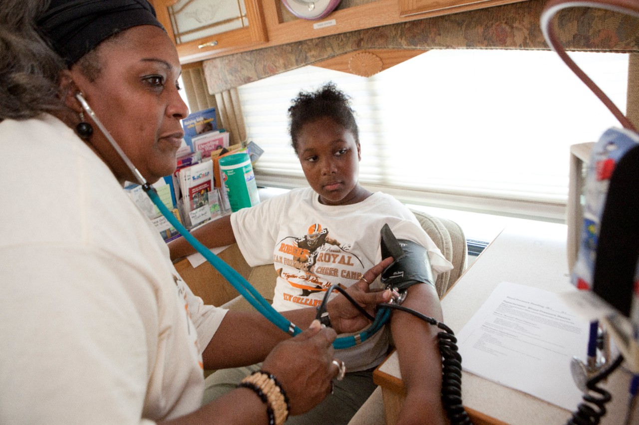 A medical professional checking patient's blood pressure.