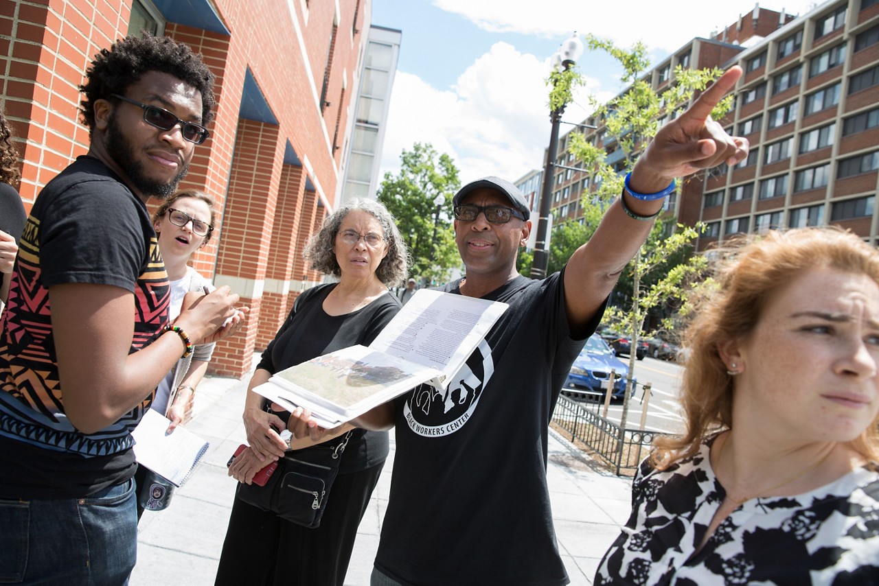 Community organizers talk while touring a neighborhood. Community organizers talk while touring a neighborhood.