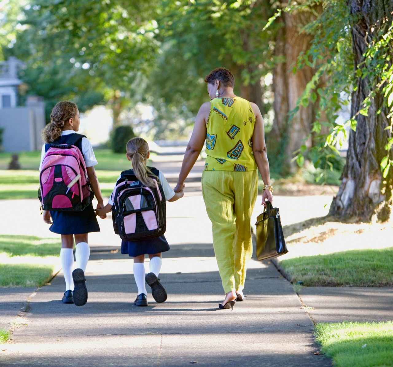 A mother walks hand in hand with her two children.