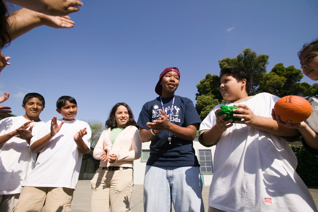 Site coordinator, Felice Archbold, with students in the after school program of Sports 4 Kids, (Playworks) play dodge ball at Urban Promise Academy, Oakland, California.