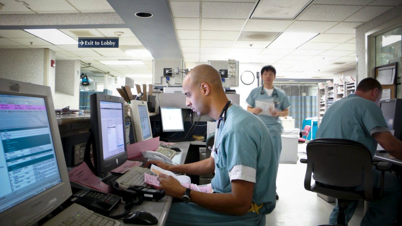 Health professional in a hospital typing patient information into a computer.  Expecting Success