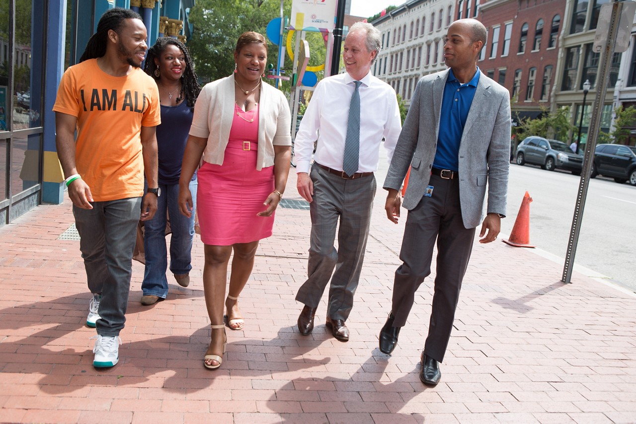 RWJF COH Louisville August 25-28, 2016 Office of Safe and Healthy Neighborhoods members together in downtown Louisville: Quaniqua Carthan (long braids, blue dress), Rashaad Abdur-Rahman, director (blue shirt), Mayor Greg Fischer (white shirt, tie), Yvette Gentry (pink dress), Brandyn Bailey (orange shirt). tyrone@tyronefoto.com