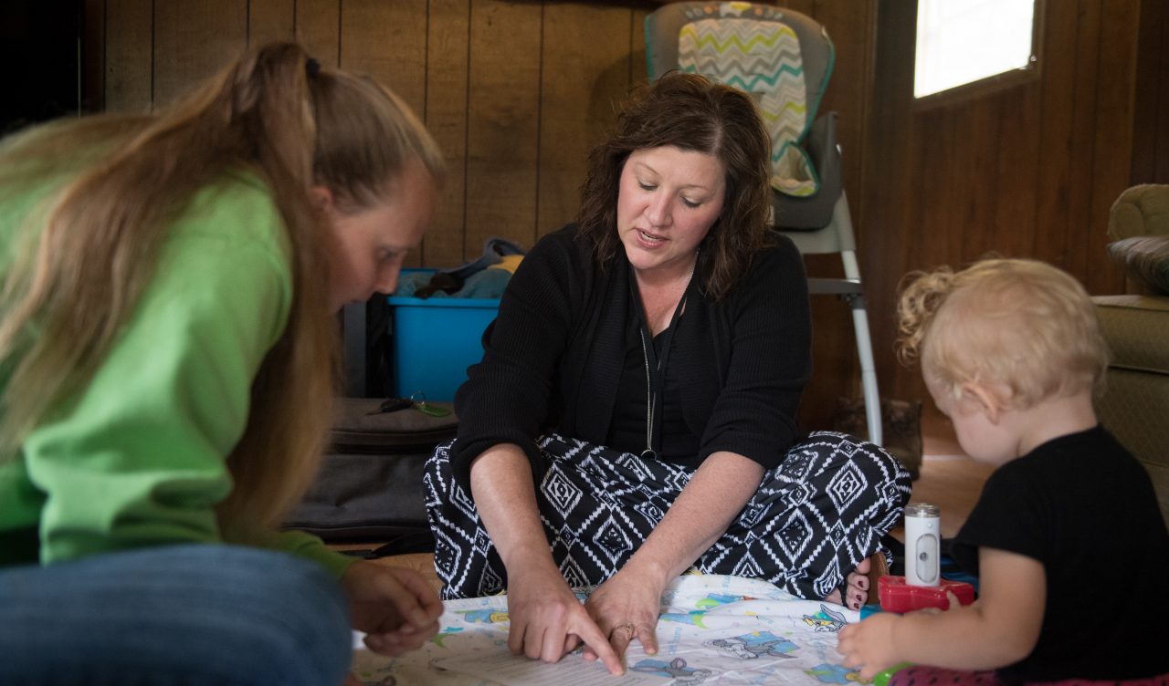 Maria Friend, center, Director of Early Care Programs, visits with Sonya Kisner and her daughter Catherine Ann Kisner, 13 months, in their Oakland, Maryland home as part of Healthy Families Garrett County. The early care program is voluntary for families who wish to participate and targets the developmental years from newborn to three years old. The visiting nurse offers advice, monitors a baby's weight, physical and mental development, and can assist mothers in connecting to county services.