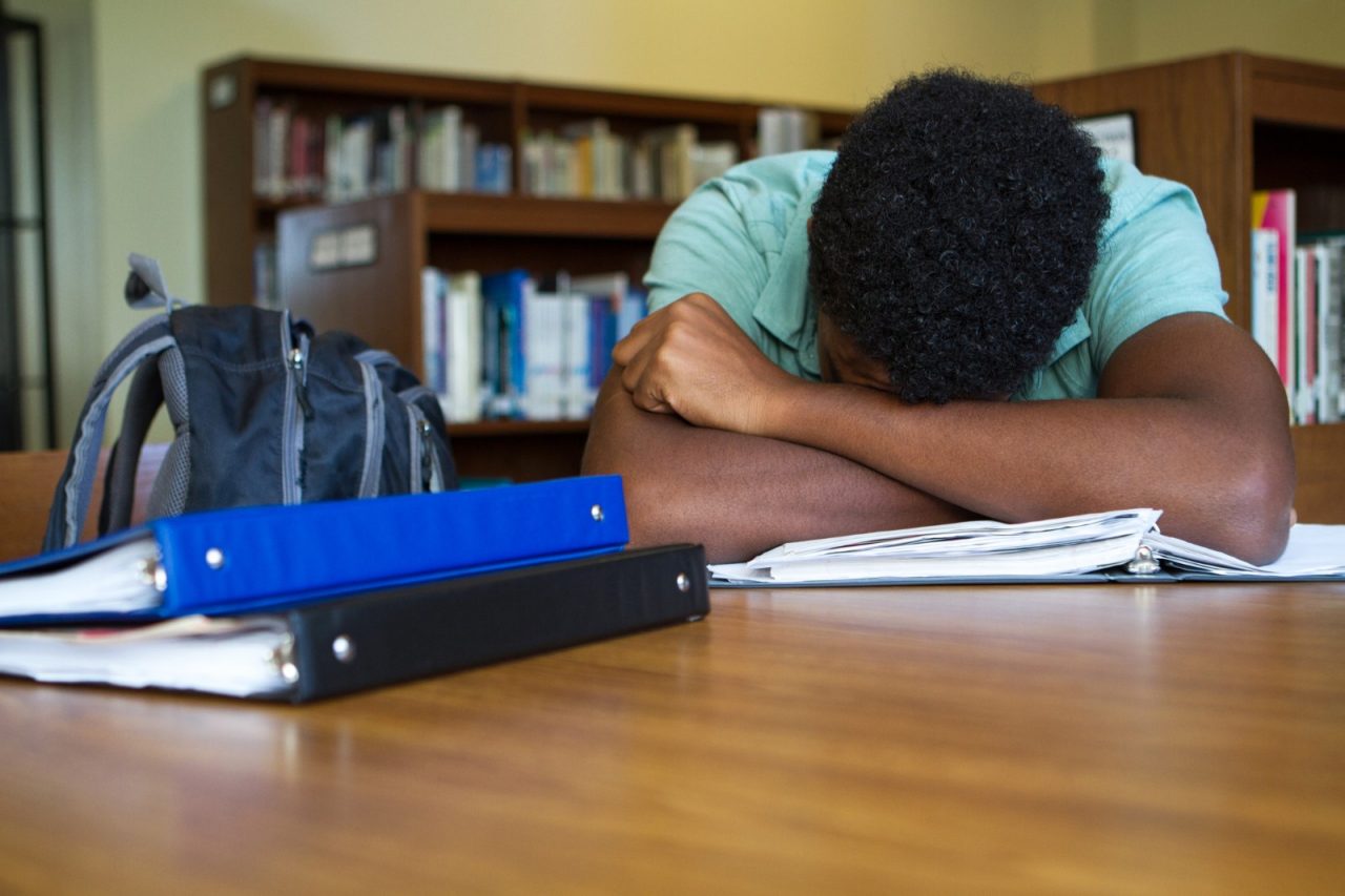 African American student overwhelmed with homework.