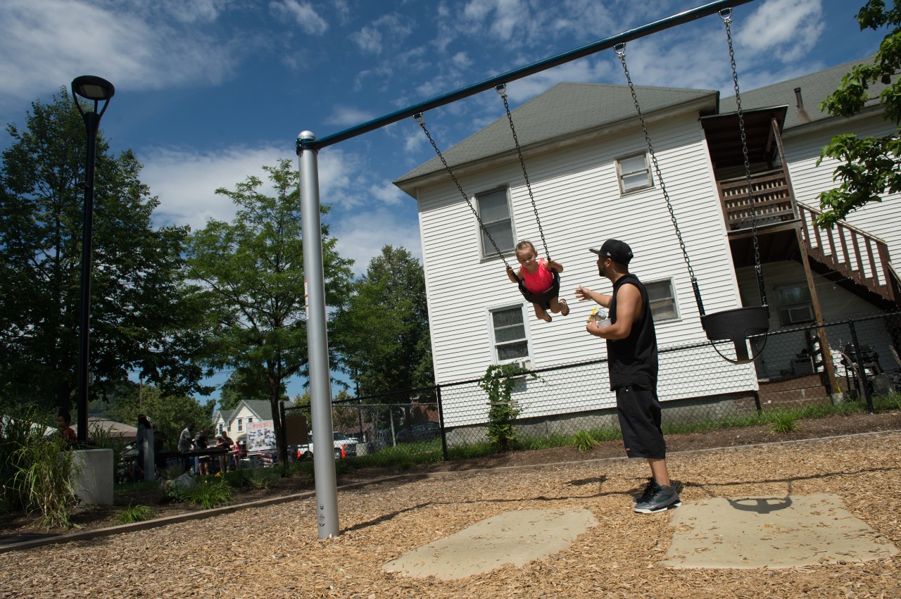 Mike Cruz swings his daughter Mikaylah Cruz, 3, on the new swingset in Harriman Park during the park's Ninth Annual Cookout and Block Party in Manchester, N.H. on Thursday, Aug. 18, 2016. The cookout is a chance to bring community members together, but was special this year because of the new playground installed at the park.
