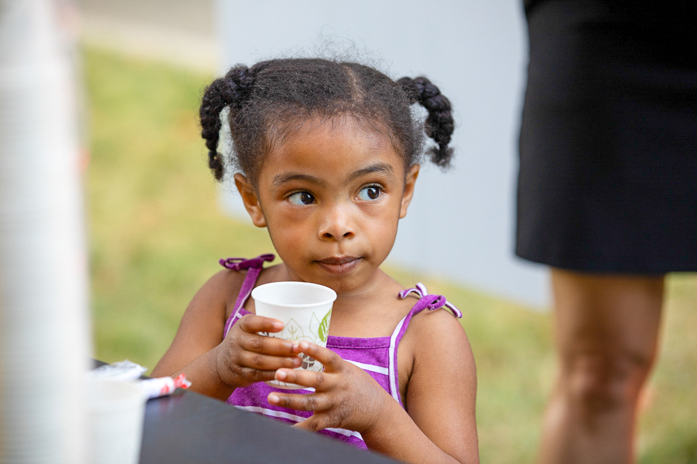Young girl drinking from a cup.
