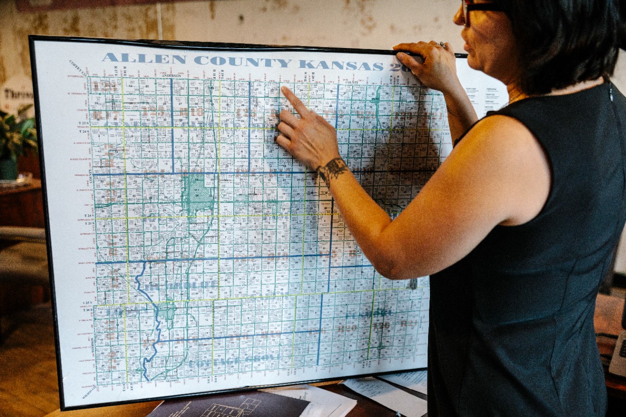 Iola, KS - August 1, 2017 - Elizabeth Gambill points to a map of Allen County in the THRIVE offices, located off the town square in downtown Iola.
