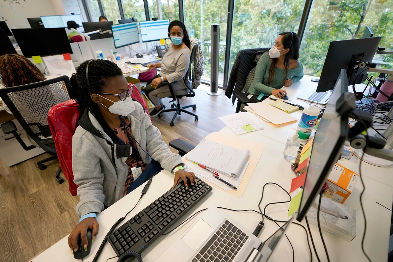 Contact tracers, from left to right, Christella Uwera, Dishell Freeman and Alejandra Camarillo talk about a case at Harris County Public Health contact tracing facility Thursday, June 25, 2020, in Houston. Texas Gov. Greg Abbott said Wednesday that the state is facing a "massive outbreak" in the coronavirus pandemic and that some new local restrictions may be needed to protect hospital space for new patients. (AP Photo/David J. Phillip)