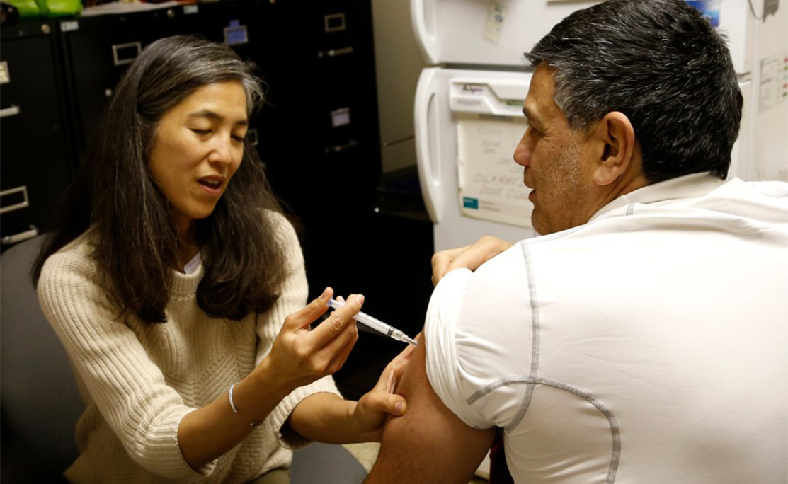 Dr. Morita giving a flu shot at a clinic during her tenure with the Chicago Department of Public Health.