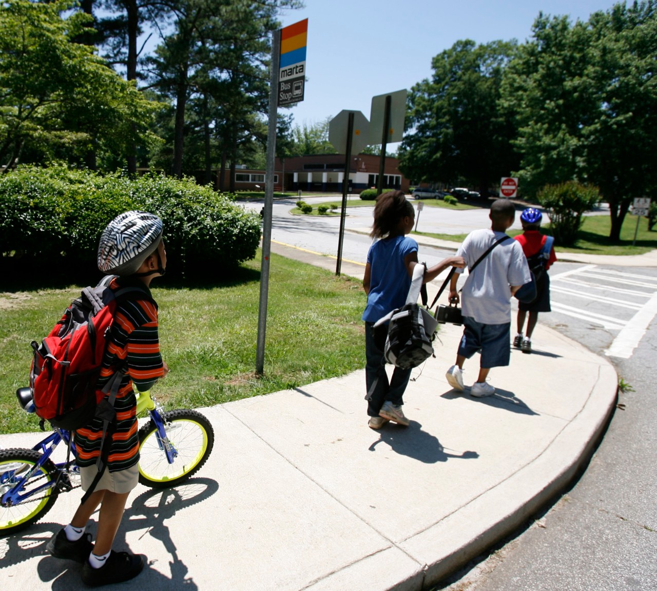Children crossing street on way to or from school. Some children walking, others riding bikes.  Safe Routes to School at Knollwood Elementary in Decatur, GA.