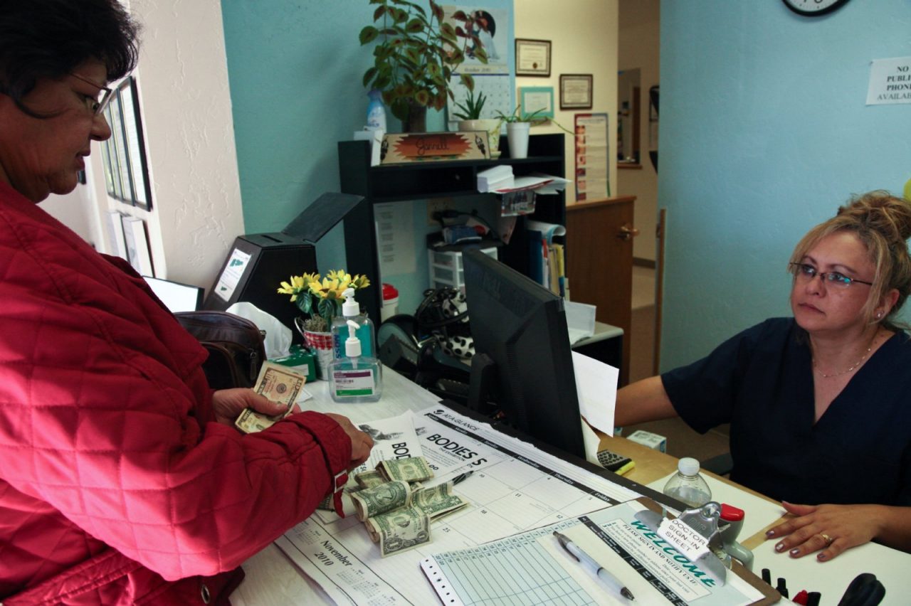 Patient pays with a wad of cash, Hidalgo Medical Services-Bayard Community Health Center, Bayard, New Mexico. Project ECHO