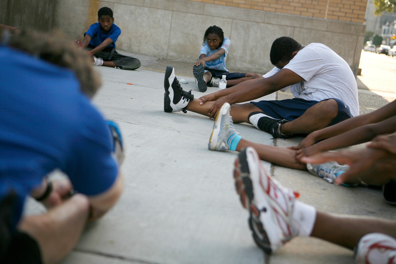 High school student Kenyon McGriff and fellow members of Students Run Philly Style, warm up before a run. They are led by coach Scott Baier.  Commission to Build a Healthier America - Kenyon McGriff. Philadelphia, PA.