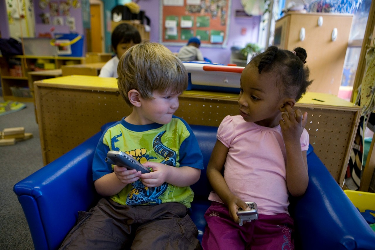 Nariya Farrington and a classmate play together with make-believe phones in classroom. Frank Porter Graham Child Development Center in Chapel Hill, North Carolina.