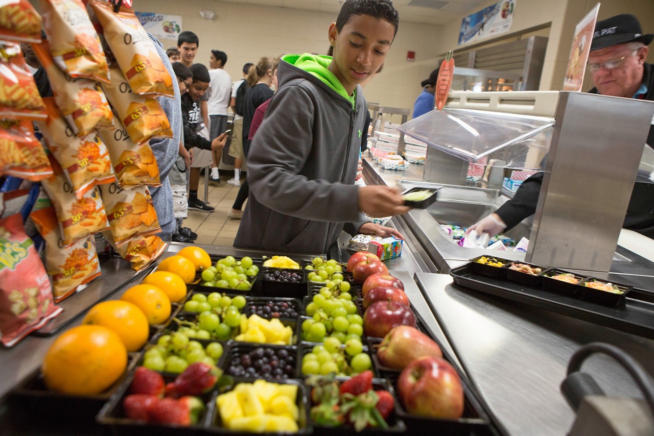 Teenager in school cafeteria chooses healthy lunch at Lawton Chiles Middle School Dining Services. Signs of Progress, Florida.