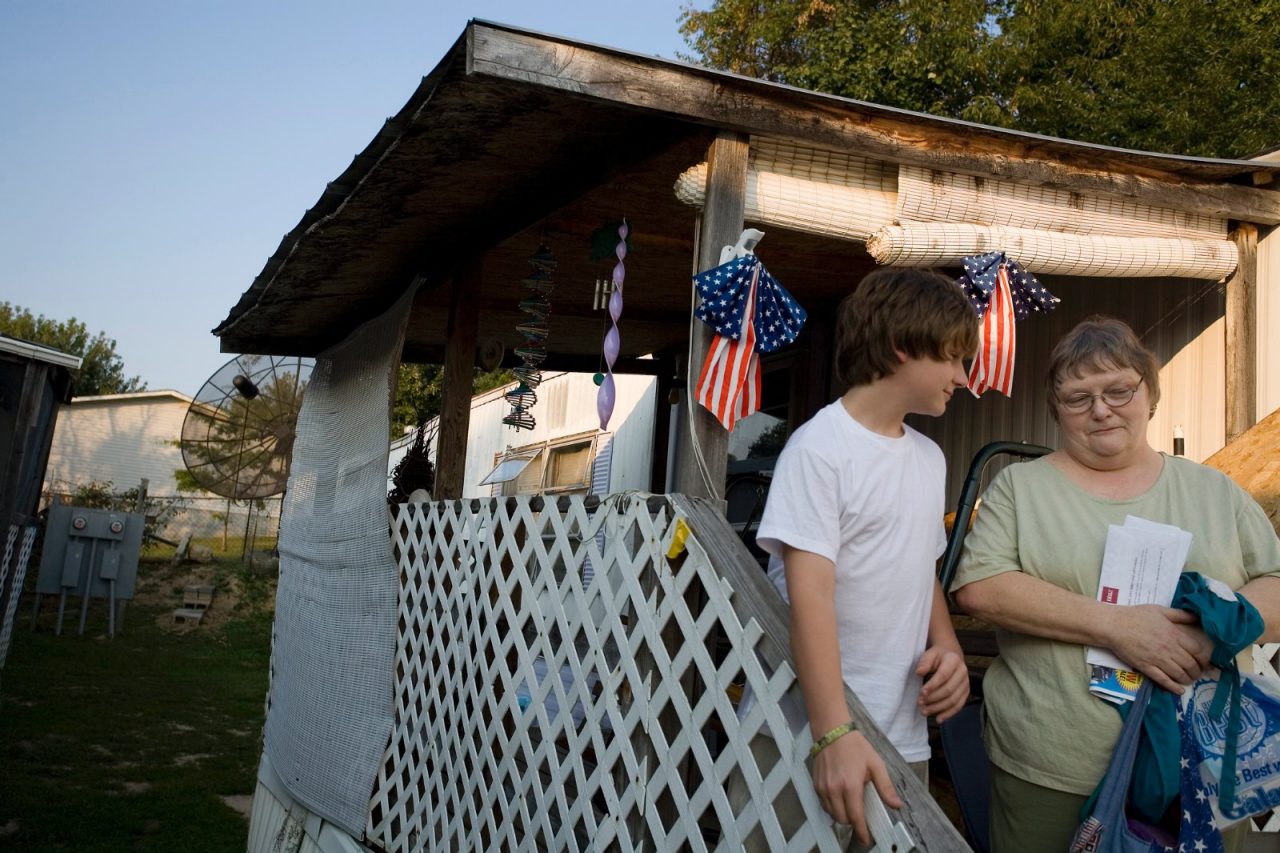 Yvonne Dempsey who has diabetes, and a boy stand outside her trailer home. The Elkins family of Oak Hill, West Virginia, have health issues. Commission to Build a Healthier America - Elkins Family