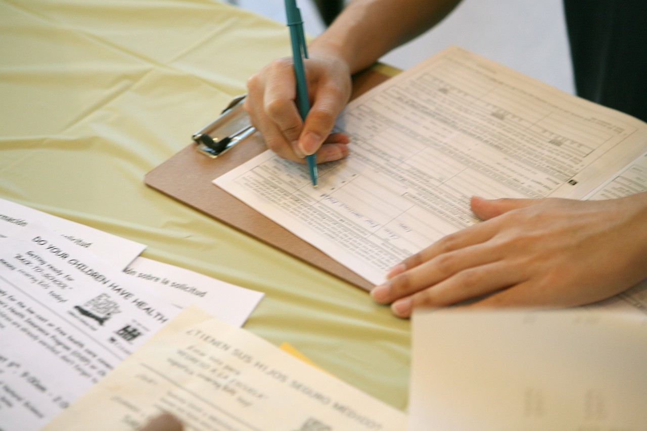 A man fills out an application for SCHIP (State Children's Health Insurance Program) at a Covering Kids &  Families enrollment event. Covering Kids & Families