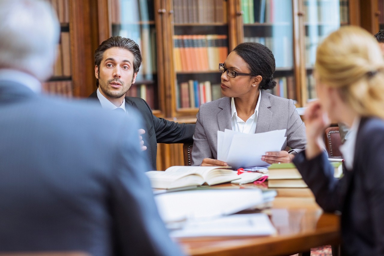 A group of professionals discuss research findings during a meeting.