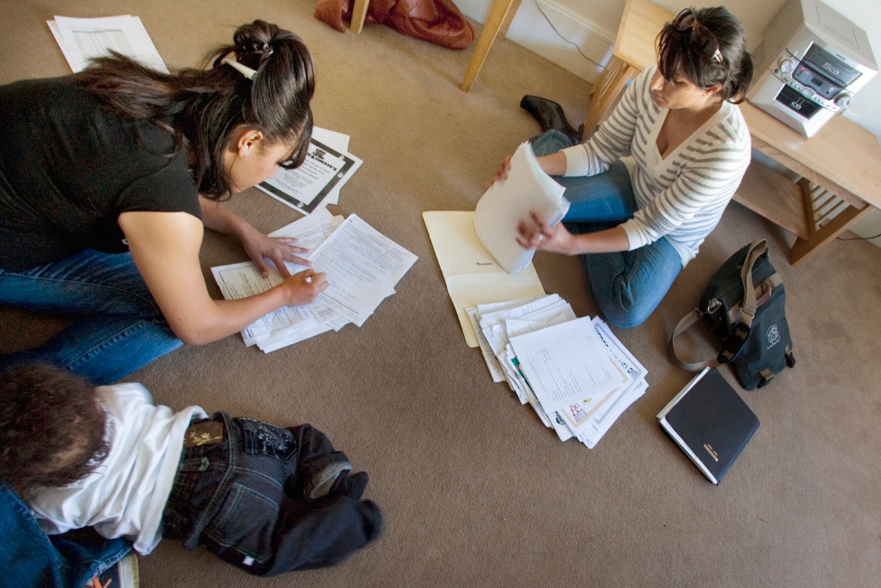 Maria Allen a former foster child and her son, Za-cari, meet in her new apartment with Jasminder Dhahan,  youth advocate from First Place For Youth a few weeks after moving in. Oakland, CA. First Place for Youth.