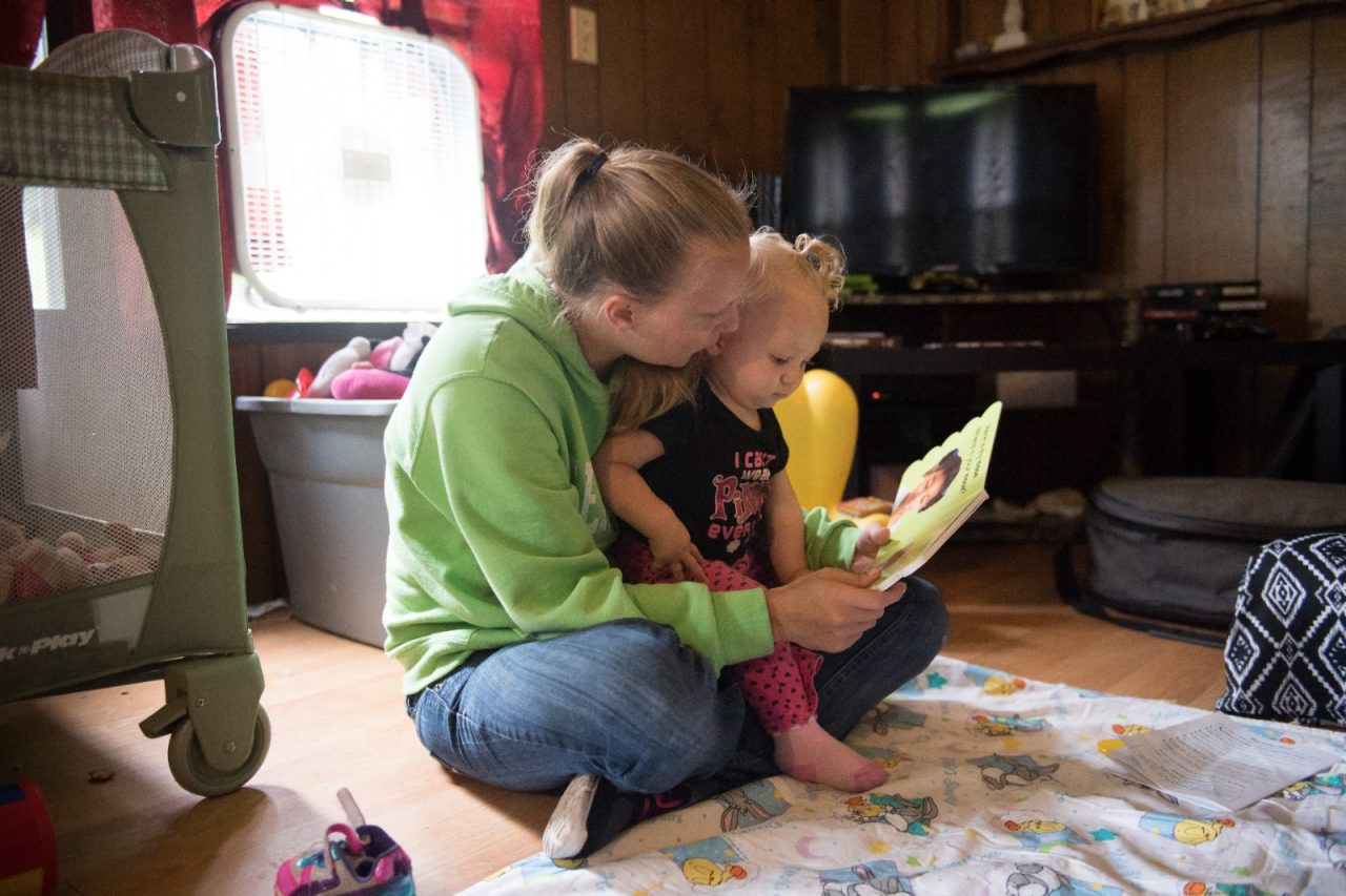 Sonya Kisner reads to her daughter Catherine Ann Kisner, 13 months, during a home visit as part of Healthy Families Garrett County. The early care program is voluntary for families who wish to participate and targets the developmental years from newborn to three years old. The visiting nurse offers advice, monitors a baby's weight, physical and mental development, and can assist mothers in connecting to county services.