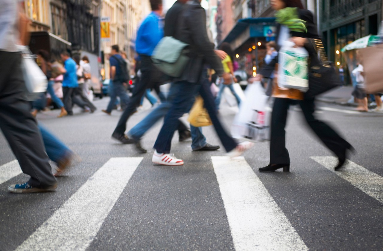 .Pedestrians crossing the street within a city crosswalk.