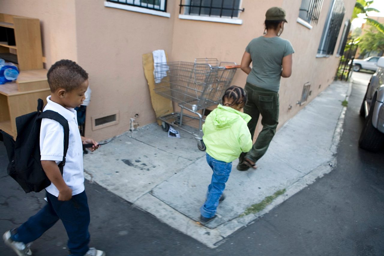 Beverly Davis and her children Alyla (daughter) and Semaj (son), walking to their home. Beverly is a single mother suffering from Crohn's Disease.  Commission to Build a Healthier America - Beverly Davis. Long Beach, California.