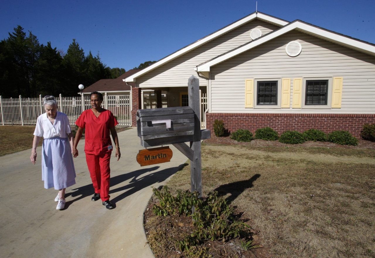An elderly nursing home resident and a shahbaz from the Green House Project in Tupelo, MS go for a walk.