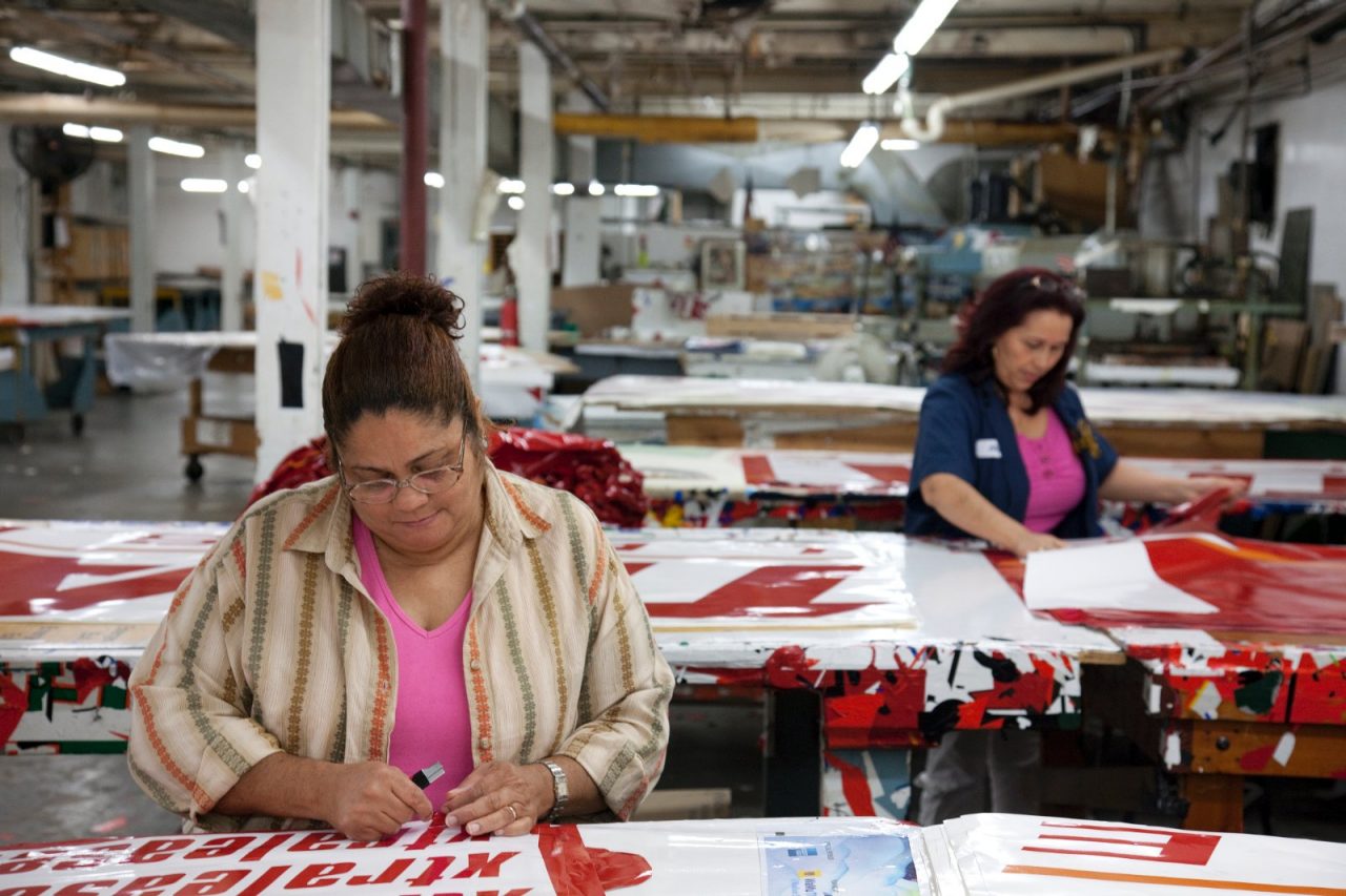 Women working to fabricate promotional banners.