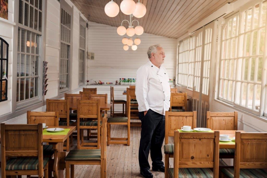 Man stands in empty restaurant.
