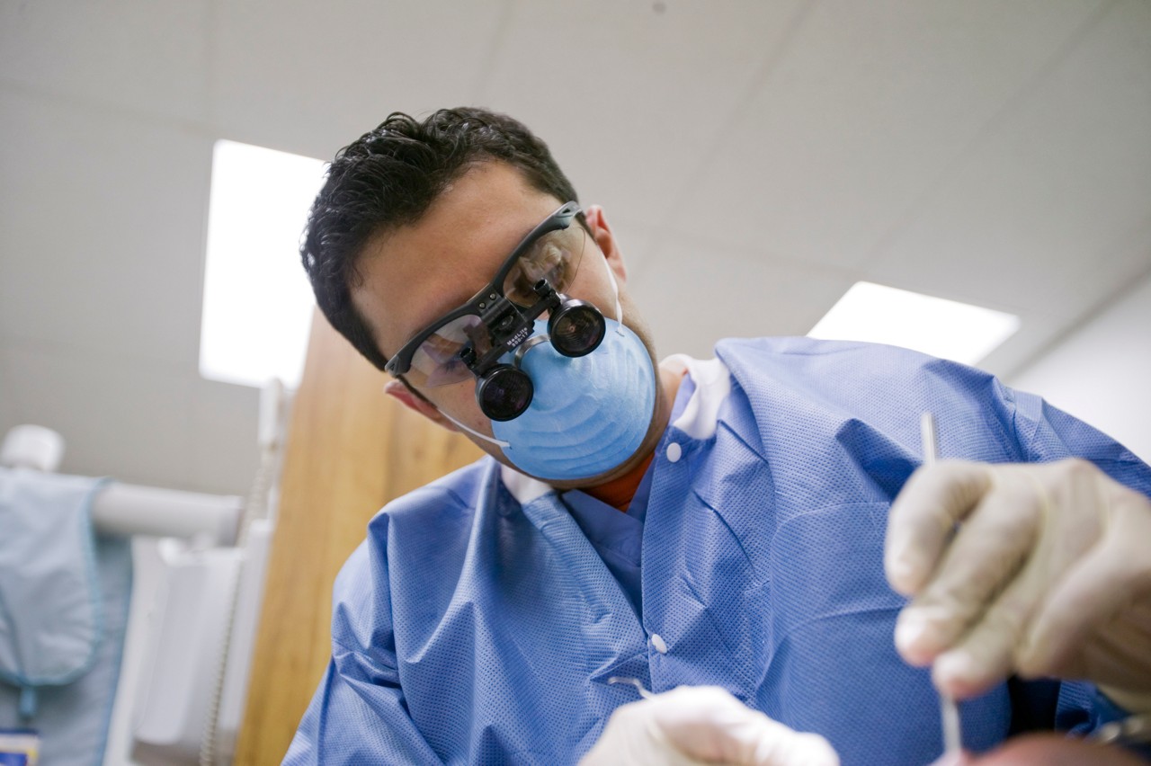 Victor Gonazales, dental student, performs an oral procedure at the community based clinic at the University of Illinois at Chicago. Pipeline, Profession and Practice: Community Based Dental Education.