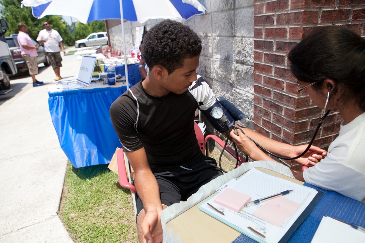 A medical professional checking a man's blood pressure.