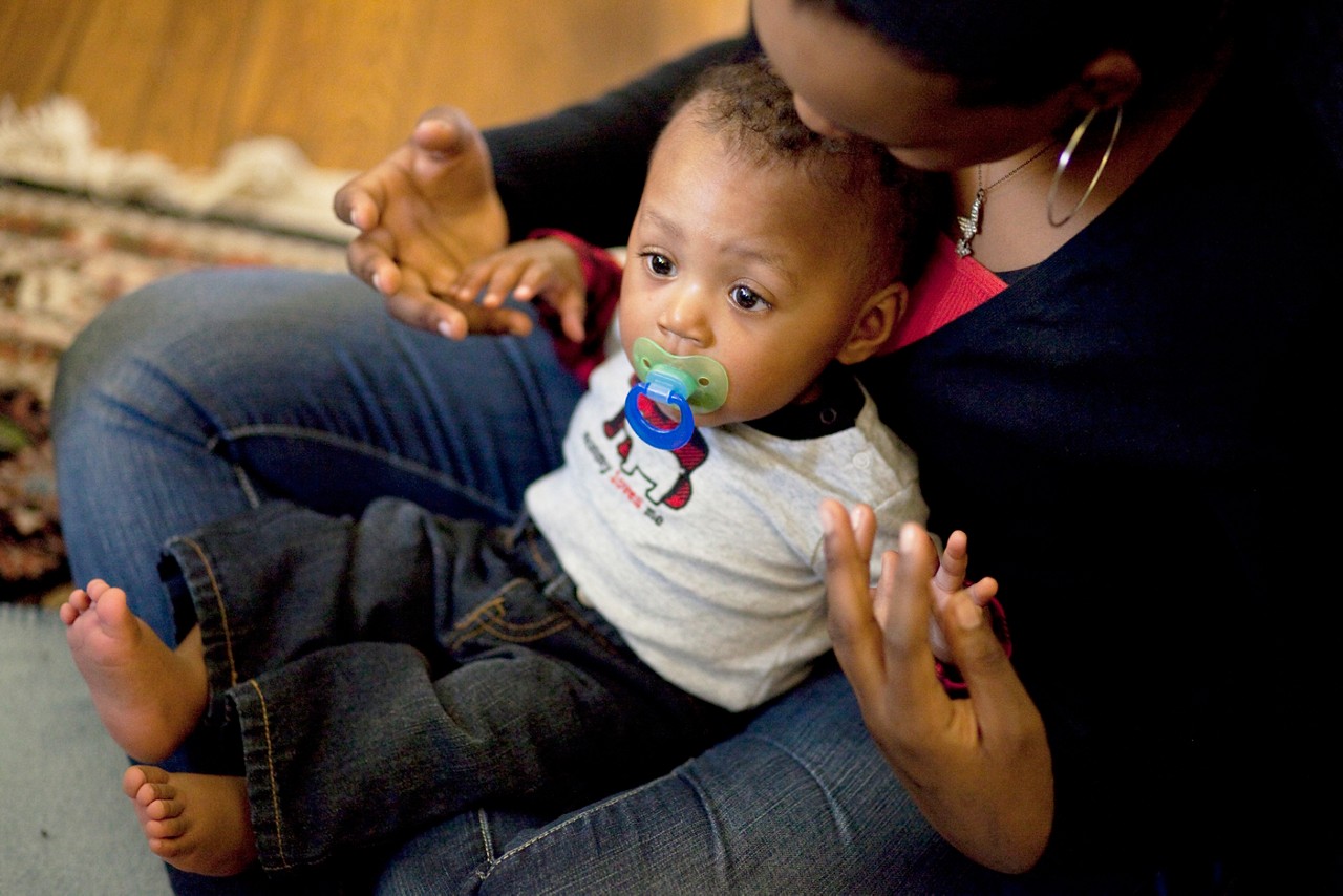 Child First program care coordinators and clinicians meet with families in Norwalk, CT.

Joshua Joubert, 8 months, with mom, Berea Joubert, 16, black shirt, red undershirt, and grandmother, Gala Joubert, green shirt. (African American family). With Child First team, Gail Melanson , blonde hair and colorful shirt with skirt, and Faiza Anwar-Junaidi.