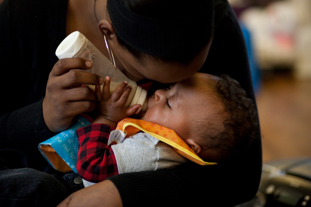 A young mother feeding her infant with a bottle of milk. Joshua Joubert, 8 months, with mom, Berea Joubert, 16, Child First program care coordinators and clinicians meet with families in Norwalk, CT.
