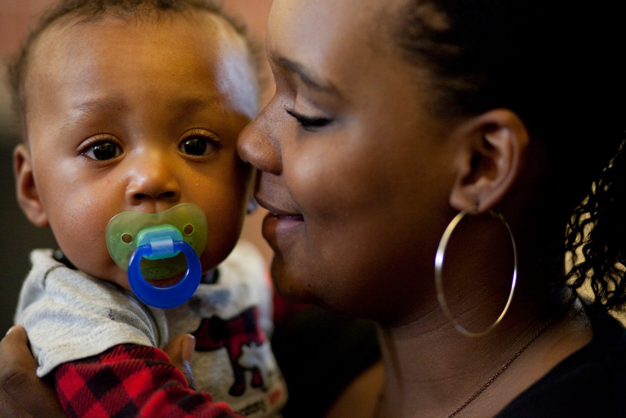 Child First program care coordinators and clinicians meet with families in Norwalk, CT.

Joshua Joubert, 8 months, with mom, Berea Joubert, 16, black shirt, red undershirt, and grandmother, Gala Joubert, green shirt. (African American family). With Child First team, Gail Melanson , blonde hair and colorful shirt with skirt, and Faiza Anwar-Junaidi.